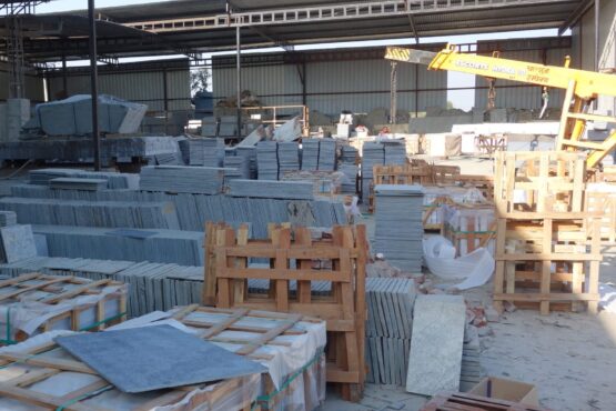 Natural stone slabs and packed crates at Indian Natural Stones north factory for processing, storage, and export operations