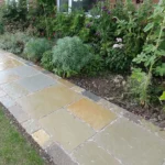 Indian Natural Stones Kota Brown limestone slabs and blocks stacked at stone yard for outdoor flooring, paving, and construction applications.