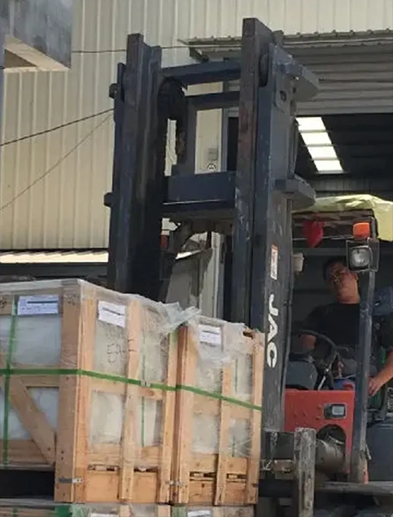 Forklift loading crated natural stone slabs for export at Indian Natural Stones warehouse