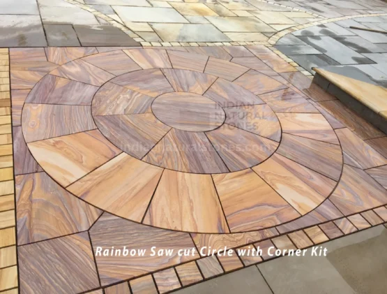 Curved landscape design with Rainbow Saw cut sandstone pavers and border cobbles from Indian Natural Stones for outdoor applications.