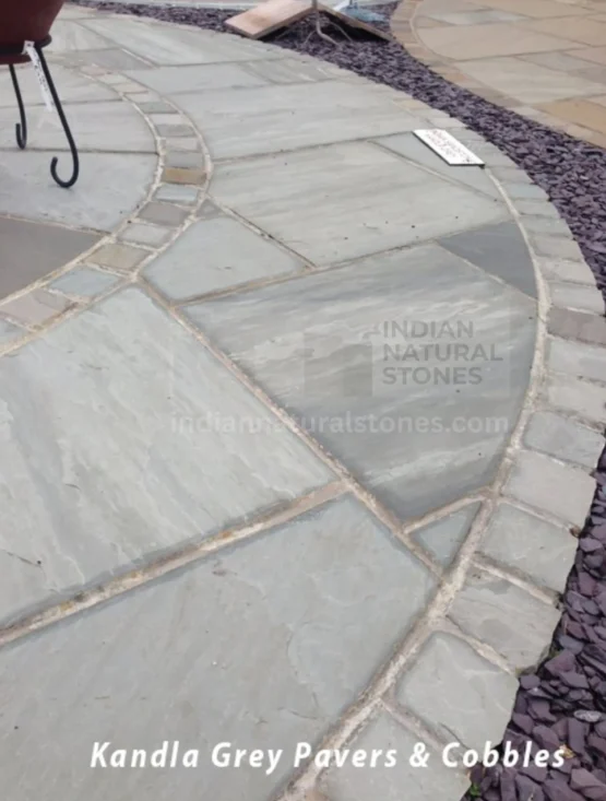 Kandla Grey Indian Sandstone pavers and cobblestone edging installed in a curved landscape pathway, showcasing the versatility and durability of natural stone by Indian Natural Stones.