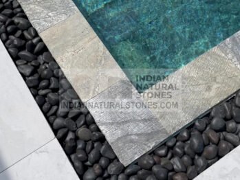 Luxury swimming pool finished with Indian slate stone tiles and pebbles for high-performance outdoor construction by Indian Natural Stones