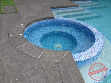 Flamed Basalt Pavers Flamed basalt stone pool coping and circular spa surround by Indian Natural Stones