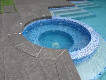 Flamed basalt stone pool coping and circular spa surround by Indian Natural Stones