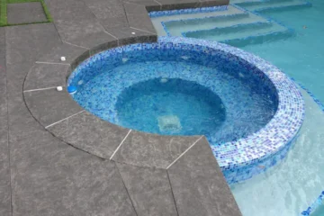 Flamed basalt stone pool coping and circular spa surround by Indian Natural Stones