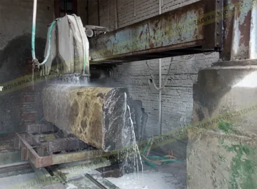 Basalt stone block being cut on industrial bridge saw at Indian Natural Stones factory for precision stone processing