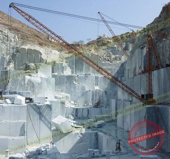 Natural stone quarrying and block extraction operations by Indian Natural Stones, showcasing large-scale stone mining and crane handling at the quarry site {{brizy_dc_image_alt imageSrc=