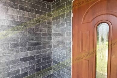 Natural slate stone wall cladding installed at a home entrance by Indian Natural Stone, showcasing textured dark slate tiles for exterior and interior architectural design.