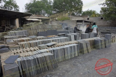 Stacked natural stone slabs and tiles at Indian Natural Stones factory yard for processing and export
