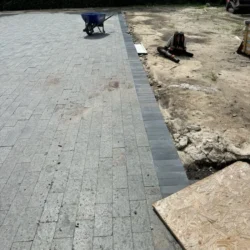 Indian Natural Stones basalt stone pavers installed for outdoor driveway and landscape paving, featuring durable dark grey basalt blocks for modern exterior flooring applications.