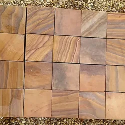 Rainbow sandstone cobblestone pavers with natural grain patterns and smooth sawn finish arranged in a grid by Indian Natural Stones.