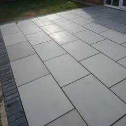 Grey honed natural stone paving slabs installed for modern outdoor patio flooring by Indian Natural Stones
