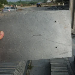 Close-up of black slate roofing tiles in hand showcasing natural texture by Indian Natural Stones