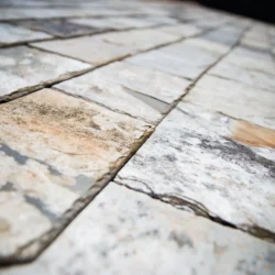 Close-up of hand touching slate roofing tiles showcasing natural texture by Indian Natural Stones