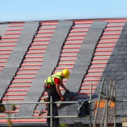 Worker installing natural slate roofing tile by Indian Natural Stones