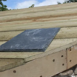 Slate roofing tile placed on wooden roof base during installation by Indian Natural Stones